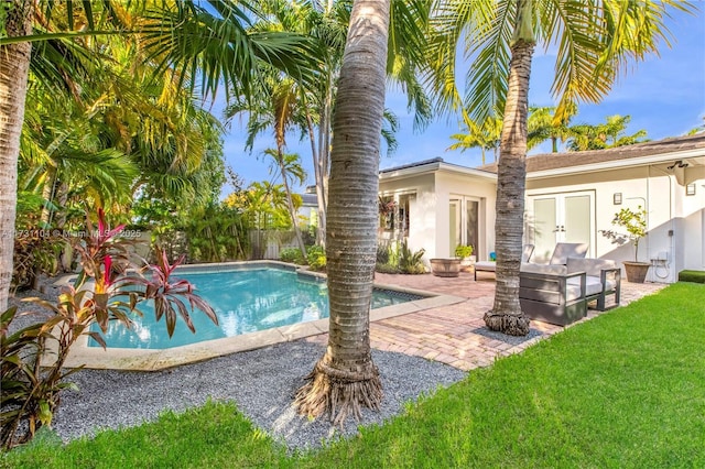 view of pool with a lawn, a patio, fence, french doors, and a fenced in pool