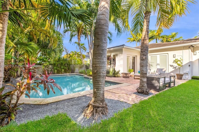 view of swimming pool with french doors, a fenced in pool, a yard, a patio, and outdoor lounge area