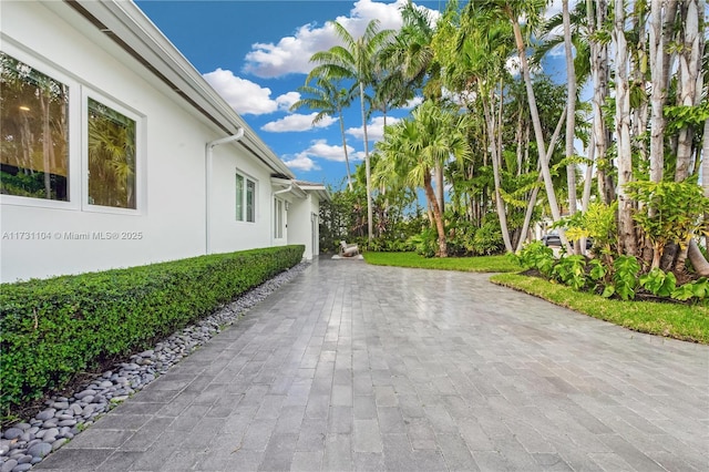 exterior space featuring stucco siding and decorative driveway