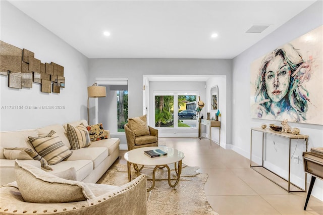 living area with light tile patterned floors, visible vents, recessed lighting, and baseboards