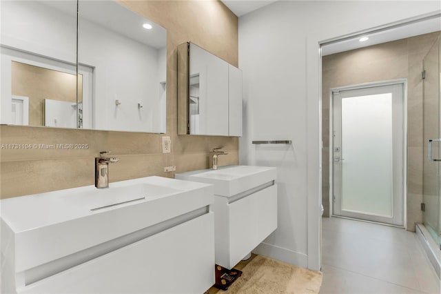 bathroom featuring recessed lighting, two vanities, and a stall shower