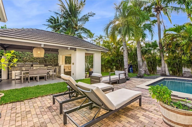 view of patio / terrace with a gazebo, an outdoor pool, an outdoor living space, and an outdoor kitchen