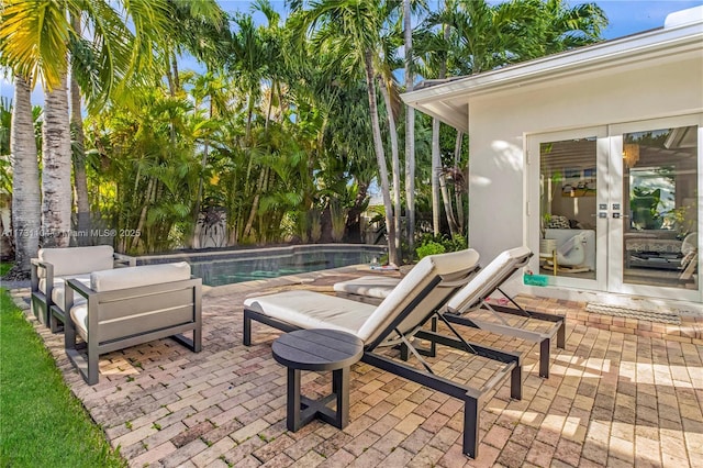 view of patio featuring an outdoor pool, french doors, fence, and an outdoor hangout area