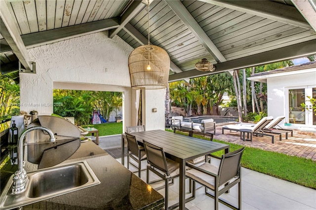 view of patio / terrace featuring fence, a sink, outdoor dining space, and an outdoor pool