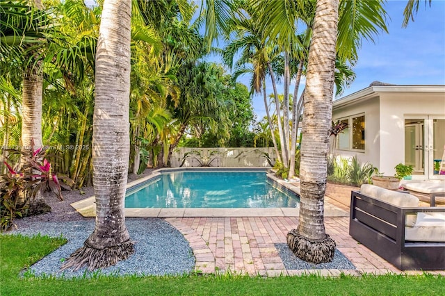 view of pool featuring a fenced in pool, a fenced backyard, and french doors