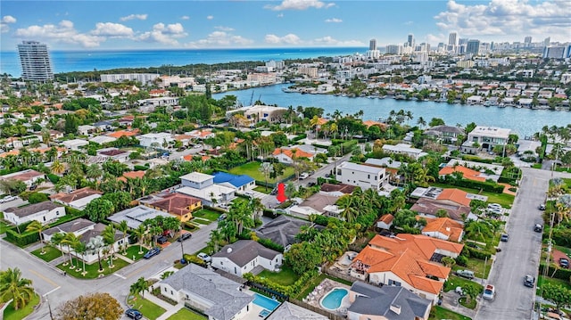drone / aerial view featuring a water view, a residential view, and a view of city