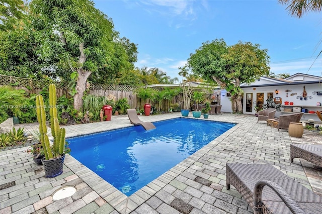 view of pool featuring a fenced in pool, french doors, a fenced backyard, and a patio