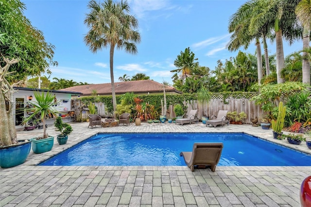 view of pool featuring a fenced in pool, fence, a fire pit, and a patio