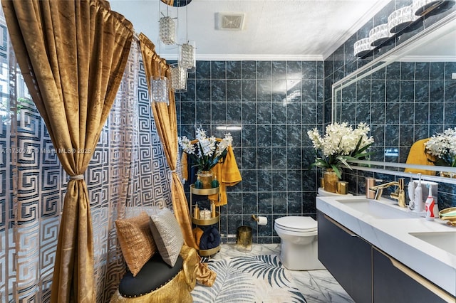 bathroom with ornamental molding, toilet, vanity, and tile walls