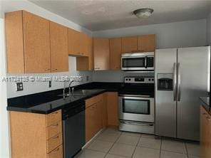 kitchen with sink, light tile patterned floors, and appliances with stainless steel finishes