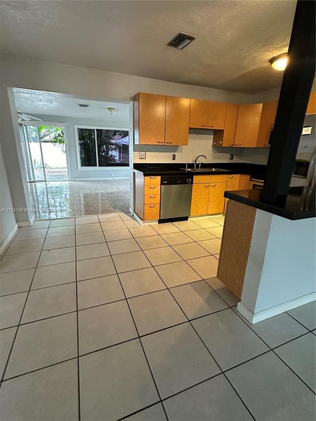 kitchen featuring sink, dishwasher, and light tile patterned flooring