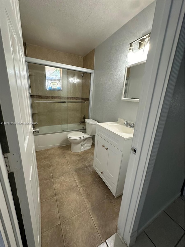 full bathroom with a textured ceiling, shower / bath combination with glass door, tile patterned floors, vanity, and toilet