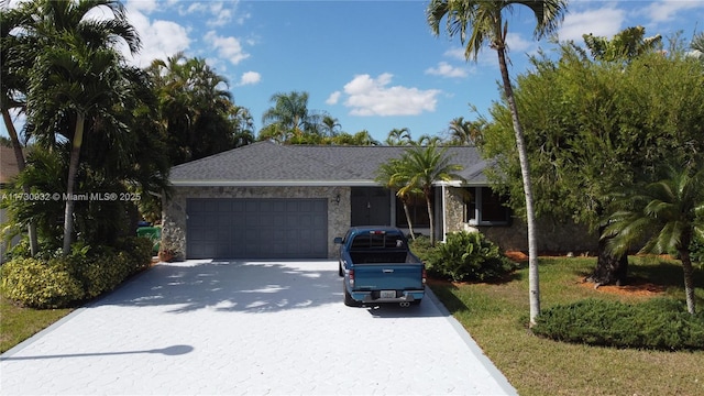 single story home featuring a garage and a front yard