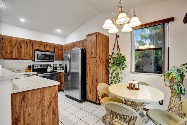 kitchen featuring lofted ceiling, sink, light tile patterned floors, appliances with stainless steel finishes, and decorative light fixtures