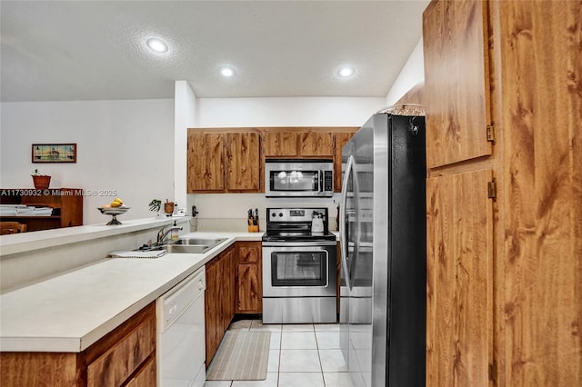 kitchen featuring stainless steel appliances, light tile patterned flooring, sink, and a textured ceiling