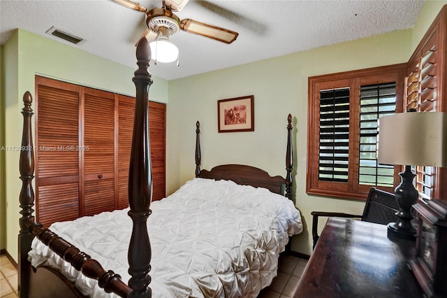 bedroom with ceiling fan, a textured ceiling, and light tile patterned floors