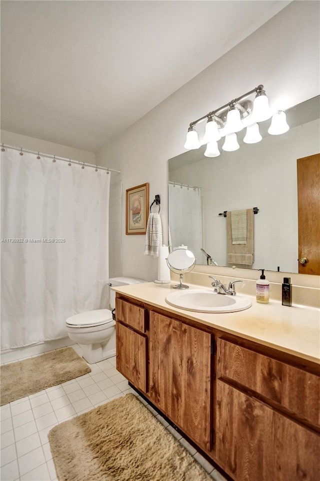 bathroom featuring vanity, tile patterned floors, and toilet