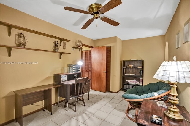 tiled home office featuring ceiling fan