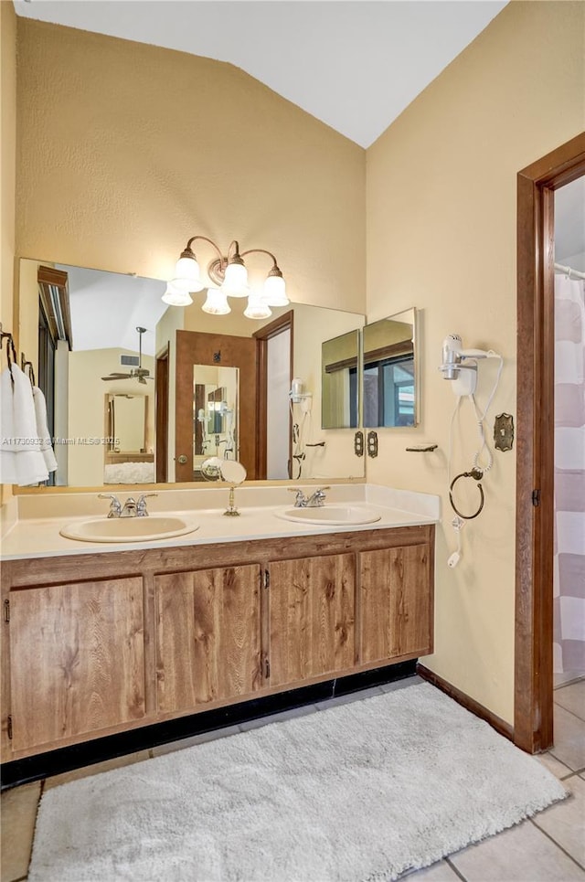 bathroom with tile patterned flooring, vanity, and lofted ceiling