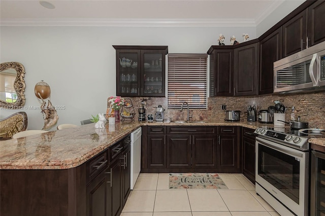 kitchen with ornamental molding, kitchen peninsula, backsplash, stainless steel appliances, and light tile patterned flooring