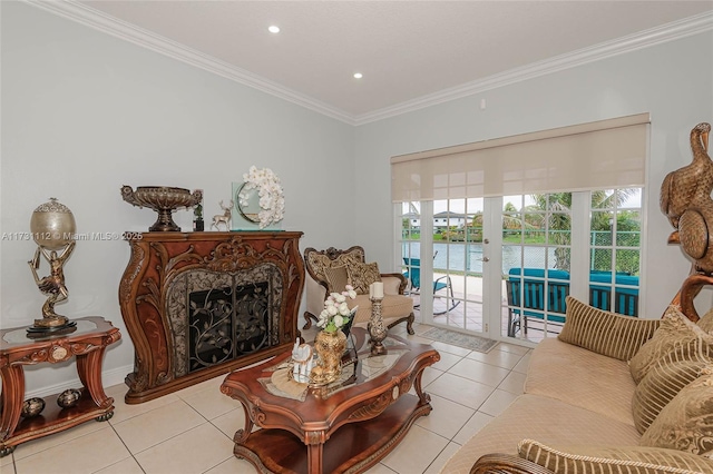 tiled living room featuring ornamental molding, a water view, a fireplace, and french doors