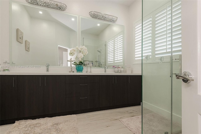 bathroom featuring vanity, hardwood / wood-style floors, and a shower with shower door