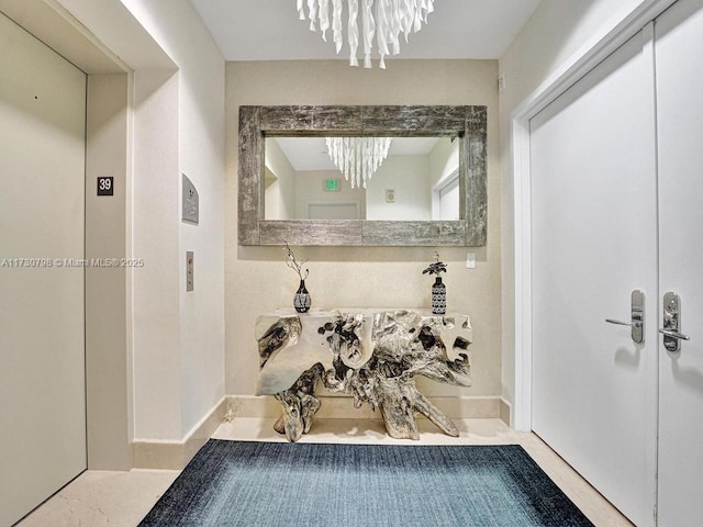 bathroom featuring elevator and an inviting chandelier