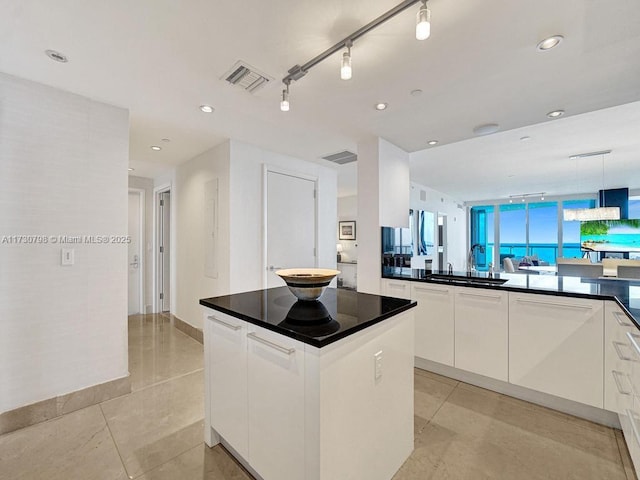 17121 Collins Ave Unit 3905, Sunny Isles Beach, FL 33160 - kitchen featuring a sink, dark countertops, white cabinets, a center island, and recessed lighting
