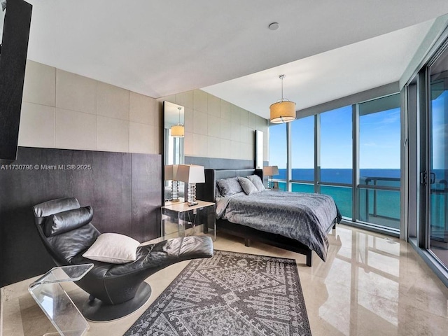 bedroom with a wall of windows and a water view