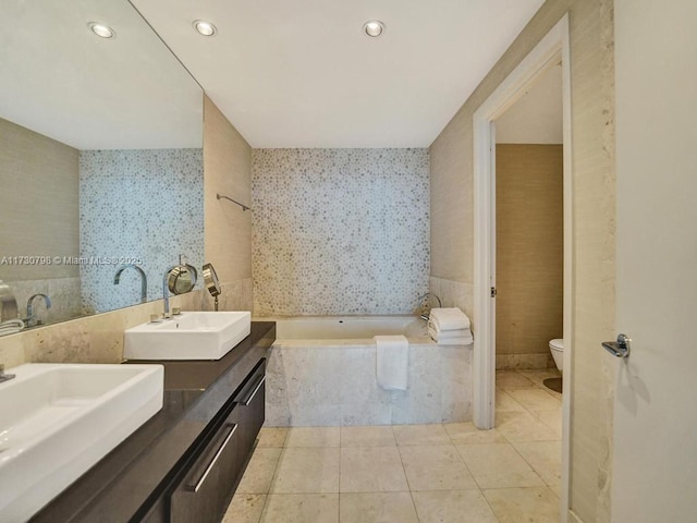 bathroom featuring vanity, toilet, tiled tub, and tile patterned flooring