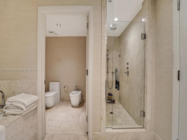 bathroom featuring a bidet, a shower with shower door, and toilet