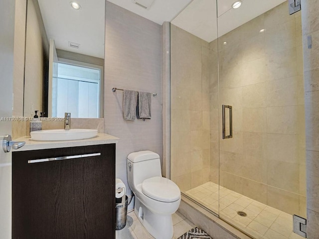 bathroom with toilet, a shower with door, vanity, and tile patterned flooring