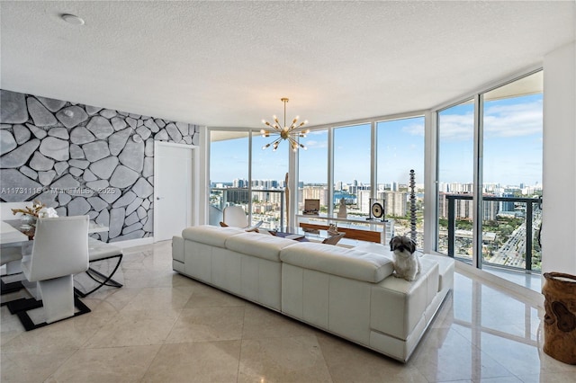 tiled living room featuring a notable chandelier, a textured ceiling, plenty of natural light, and floor to ceiling windows