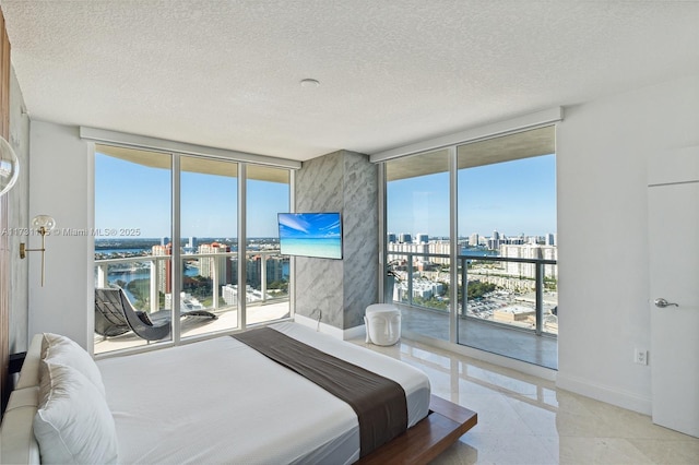 tiled bedroom featuring a textured ceiling, access to exterior, and expansive windows