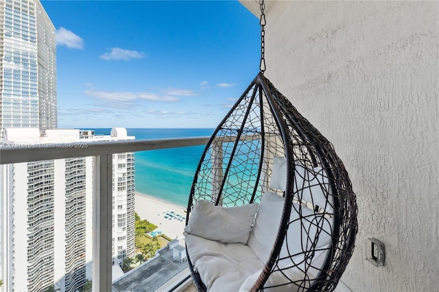 balcony featuring a water view and a beach view