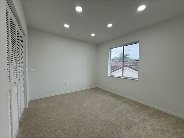 unfurnished bedroom with a closet, recessed lighting, carpet, and baseboards