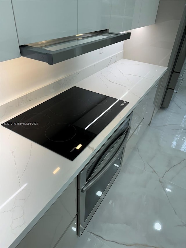 room details featuring light stone counters and black electric cooktop