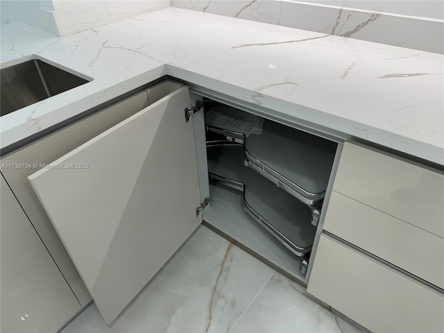 details featuring gray cabinetry and light stone counters