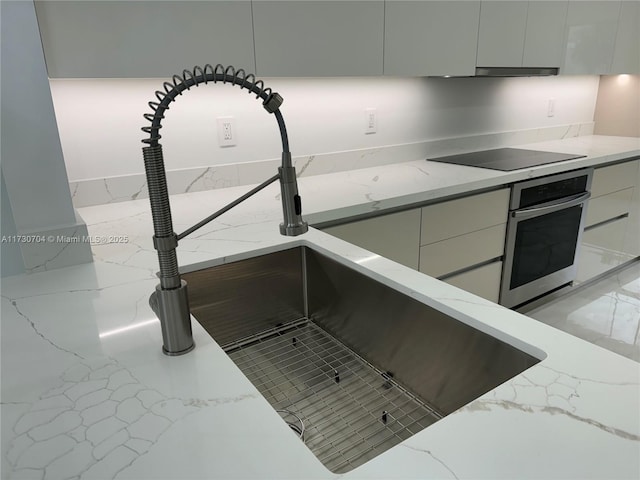 room details with white cabinetry, oven, modern cabinets, and black electric cooktop