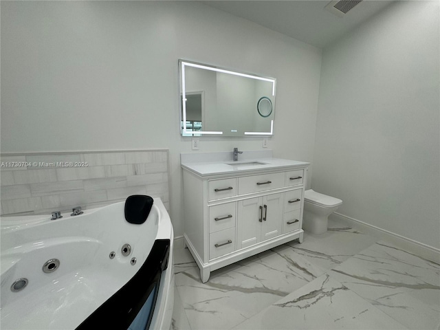 full bath featuring visible vents, baseboards, a tub with jets, vanity, and marble finish floor