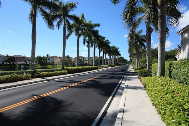 view of road with sidewalks, a residential view, and curbs