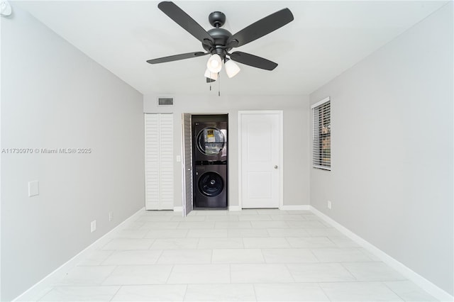 interior space featuring ceiling fan and stacked washing maching and dryer