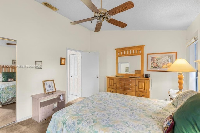 bedroom with a closet, ceiling fan, light colored carpet, and vaulted ceiling