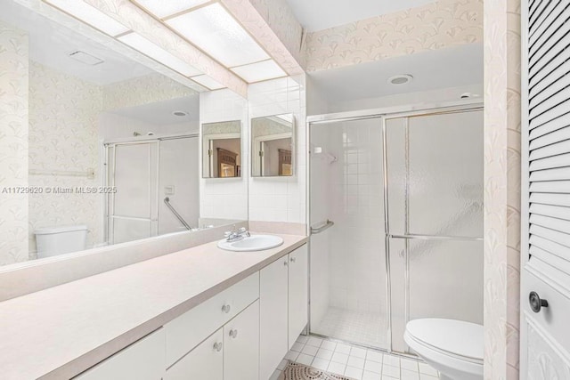 bathroom with toilet, a shower with shower door, and vanity