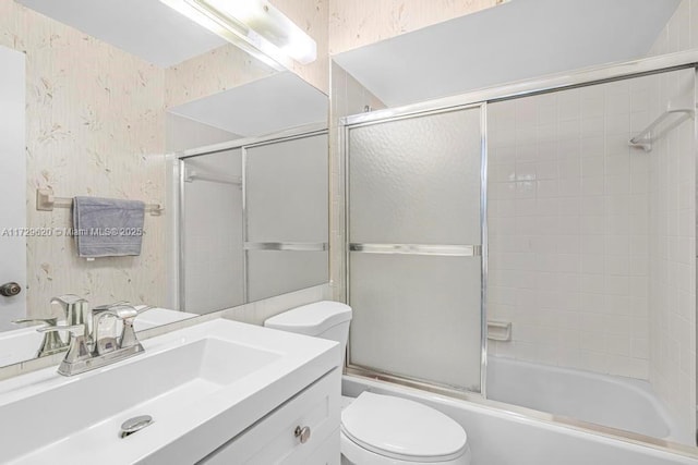 full bathroom featuring bath / shower combo with glass door, toilet, and vanity