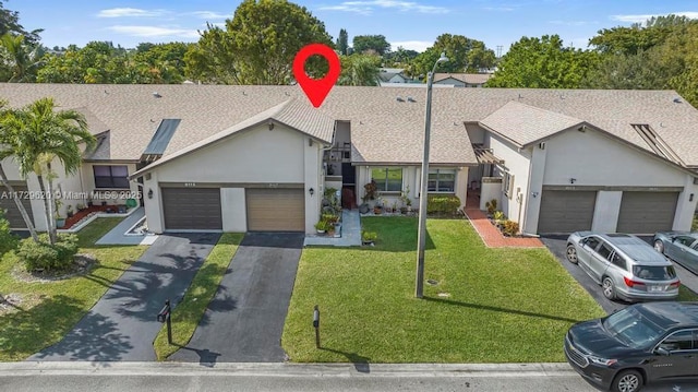 ranch-style home featuring a garage and a front lawn