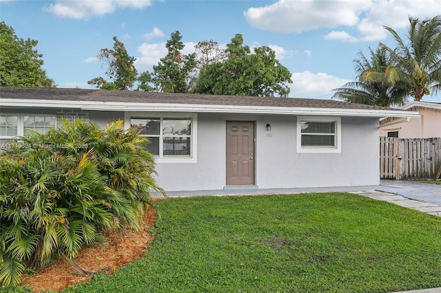 single story home featuring a front lawn