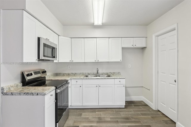 kitchen with white cabinets, appliances with stainless steel finishes, and sink