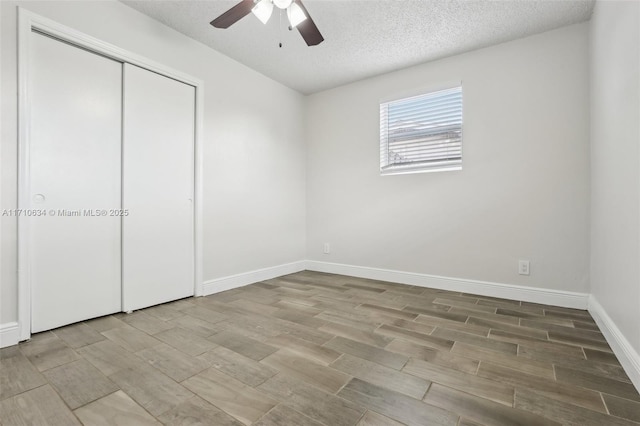 unfurnished bedroom with ceiling fan, a textured ceiling, and a closet