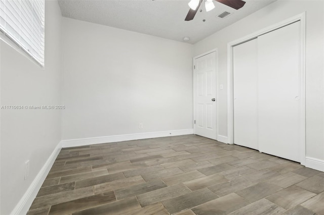 unfurnished bedroom with ceiling fan and a closet